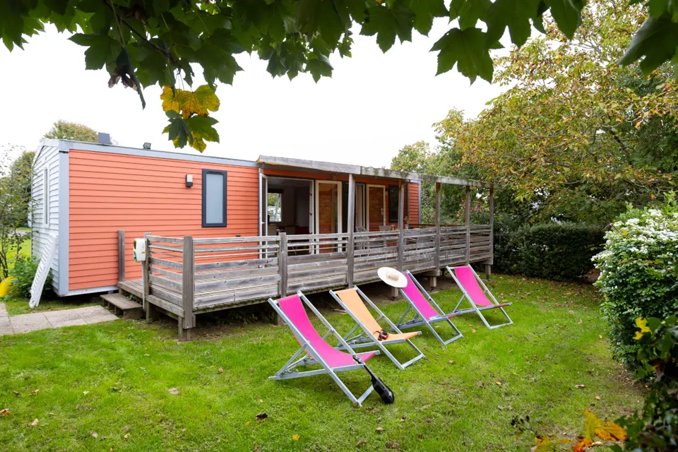 Un mobil-home du camping Ty Nénez et ses transats colorés sur la pelouse